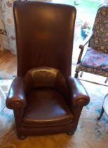 An early 20thC high-back re-upholstered rocking armchair on bun feet, Height 44", Width 28".