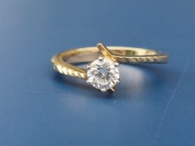 A modern crossover set diamond solitaire, the claw set brilliant weighing approximately 0.50