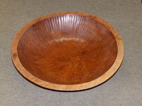 A large hand-carved wooden bowl, 28" diameter.