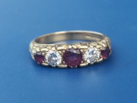 A graduated five stone ruby & diamond set 18ct gold ring. Finger size N.