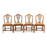 A set of four George III country Hepplewhite dining chairs, each with pierced splat back,