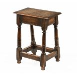 A tall oak joint stool, with moulded edge and angled turned legs with stretchers.