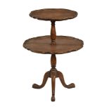 A walnut two tier shaped circular dumb waiter, raised on cabriole legs terminating in pad feet.