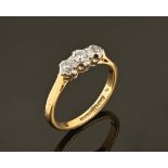 An 18 ct gold hallmarked three stone diamond ring. Size M, 2.7 grams gross.