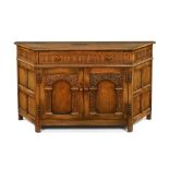 An oak sideboard, with canted angles and with knulled frieze and frieze drawer above cupboards.