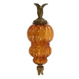 A moulded bulbous amber coloured glass lamp, with foliate gilt style fittings. +/- 44 cm high.