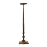A mahogany torchere, with circular top and base and raised on short scroll feet. Height 158 cm.