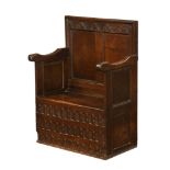 An antique oak settle, with two panelled back,