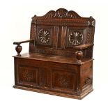 A large 17th century carved oak box settle,