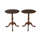 A pair of George III style mahogany tripod tables, each with moulded edge,