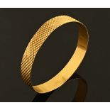 A gold coloured metal bangle, 24 grams.