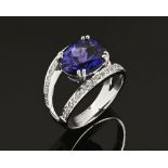 An 18 ct white gold ring, set with an oval cut tanzanite and diamonds. Size N (see illustration).