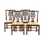A set of four Chippendale style mahogany dining chairs, each with carved top rails,
