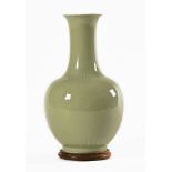 A Chinese celadon vase, with integral circular wooden stand. Height 38 cm.