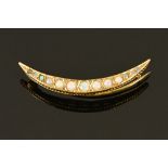 A 9 ct gold crescent moon brooch, with coloured stones, stamped 9 ct, T & G makers mark,
