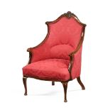 An Edwardian easy chair, with carved frame and serpentine front and raised on short cabriole legs.