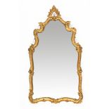 An Italian giltwood and gesso framed mirror, of shaped outline. Height 128 cm, maximum width 72 cm.