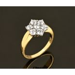 An 18 ct gold diamond daisy cluster ring, diamonds +/- .71 carats. Size M.