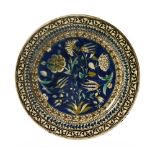 An Islamic Palistine Isnik style pottery plate, with floral decoration on a blue ground,