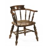 A Victorian oak office armchair, with broad arms shaped seat and turned legs.