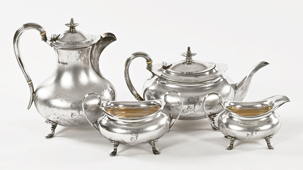 A 1920's silver four piece tea set, the tea and coffee pot both with ivory insulators,