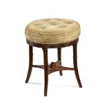 A Regency mahogany circular stool, with ring turned splayed legs united by stretchers.