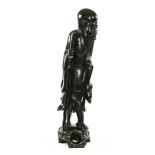 A 19th century Chinese carved ebonised immortal. Height 88 cm.