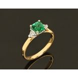 An 18 ct yellow gold emerald and diamond ring, emerald +/- .