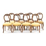 A set of eight Victorian walnut balloon backed dining chairs,