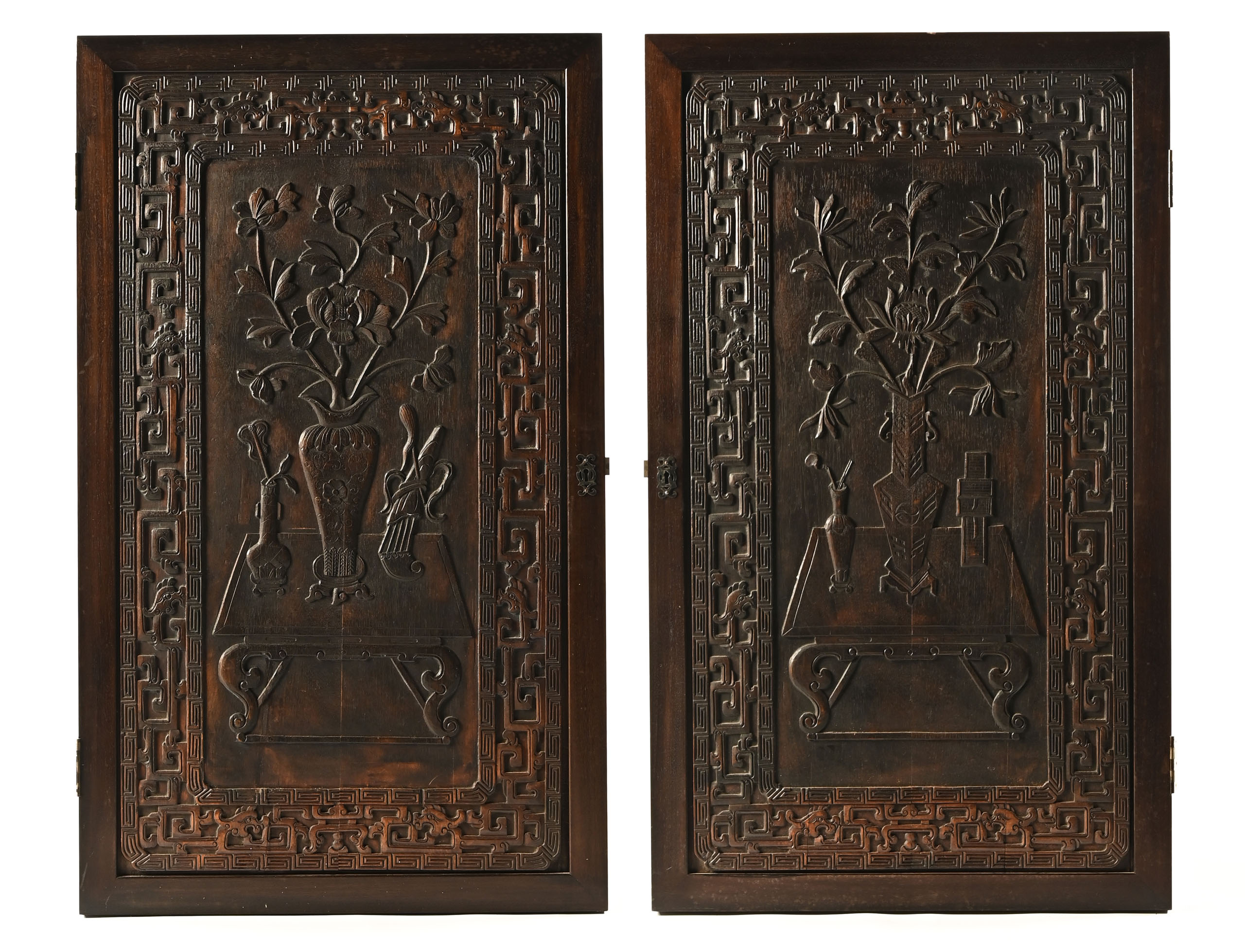 A large pair of antique Chinese carved wooden panels, depicting a table,