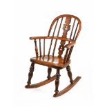 A 19th century yew wood Windsor child's rocking chair, with splat back, shaped seat,