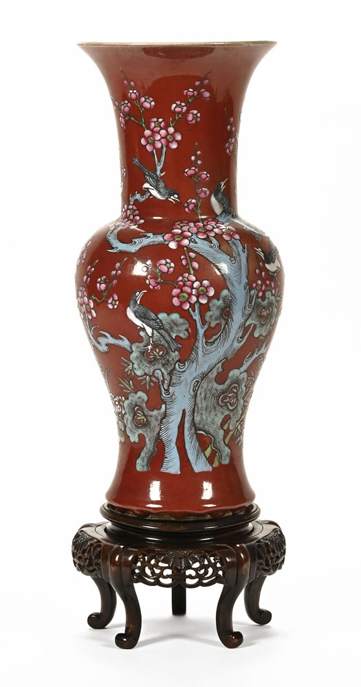 An early 20th century Chinese vase, with stylised bird and flower design on a deep red ground,