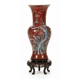 An early 20th century Chinese vase, with stylised bird and flower design on a deep red ground,