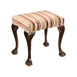 An upholstered stool, with overstuffed seat raised on cabriole legs and claw and ball feet.