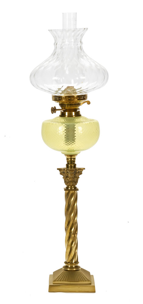 A Victorian brass oil lamp, with vaseline glass reservoir and clear shade.
