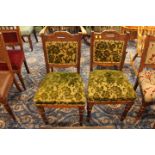 Two oak dining chairs with matching green upholstery