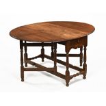 An antique oak gate leg table, twin drop flap with turned supports and low stretchers.