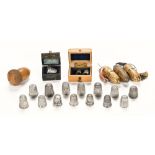 A collection of silver thimbles, one in leather and velvet lined miniature trunk,