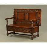 A large late 19th/early 20th century monks bench, with panelled top,