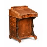 A Victorian walnut Davenport desk, of shaped outline with lidded stationery compartment,