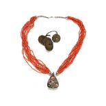 An antique Tibetan coral snuff bottle necklace, and Chinese money.