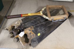 Three vintage saws and tennis racquet