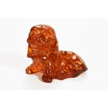 A carved amber figure of a seated dog. Height 12 cm.