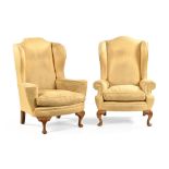 A pair of Georgian style upholstered wing back armchairs, in yellow fabric with front cabriole legs.