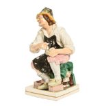 A Staffordshire figure of a seated cobbler. Height 32 cm.