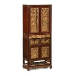 A Chinese three part lacquered cabinet, with glazed and carved doors and drawers.