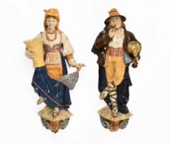 A pair of Italian early 20th century porcelain figures, in traditional dress, wall hangings,