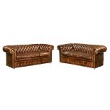 A pair of modern brown leather Chesterfield settees, of traditional button down design.