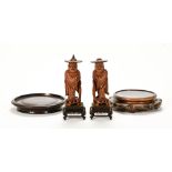 A pair of Chinese hardwood Okimono figures, modelled as Buddhist priests with prayer beads.