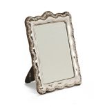 A silver framed mirror, bevelled plate with repousse border London mark 1968.